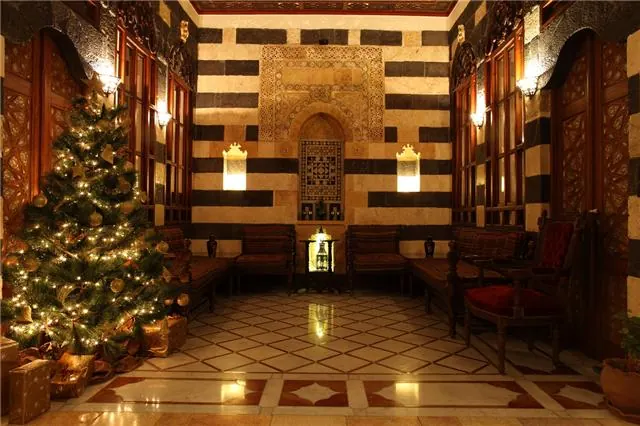 Traditional striped stone walls, carved wood and a marble fountain inside Beit Ak Bik